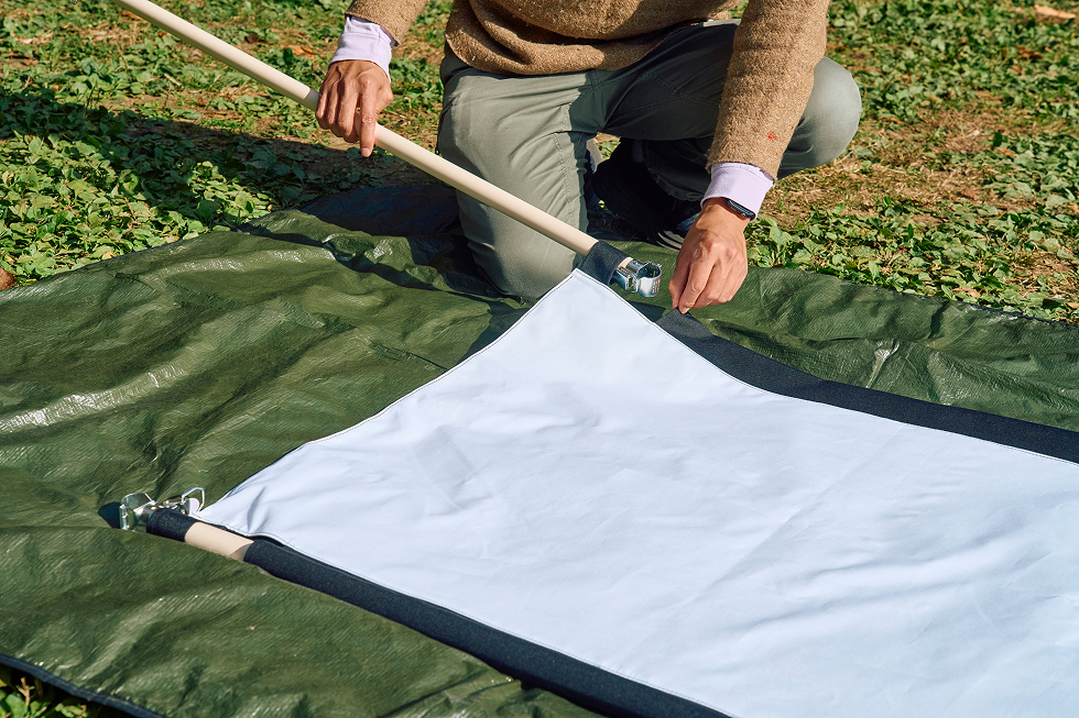 あらかじめ縫っておいたスクリーン上下のパイプ通しに、横方向のパイプを差し込む