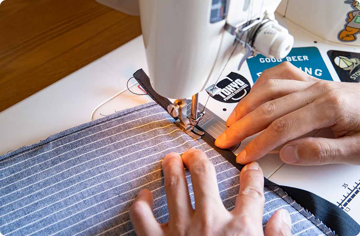 アルミシートと布生地を縫い合わせ、縁をテープで補強