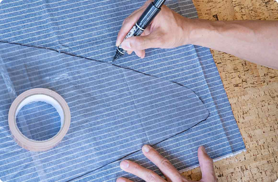 型を取った透明ビニール袋をラインに沿ってハサミでカットし、それをアルミシート、布生地の上に載せて油性マジックペンで縁取りする