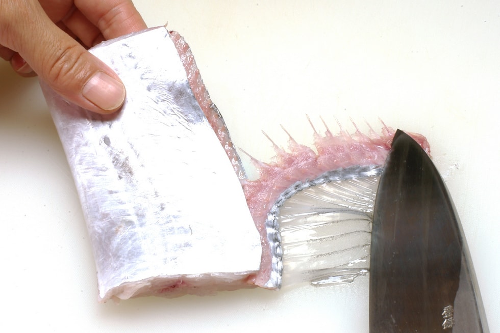 そのまま背ビレの端を包丁で押さえ、身を静かに引っ張ると小骨がきれいに剥がれる。