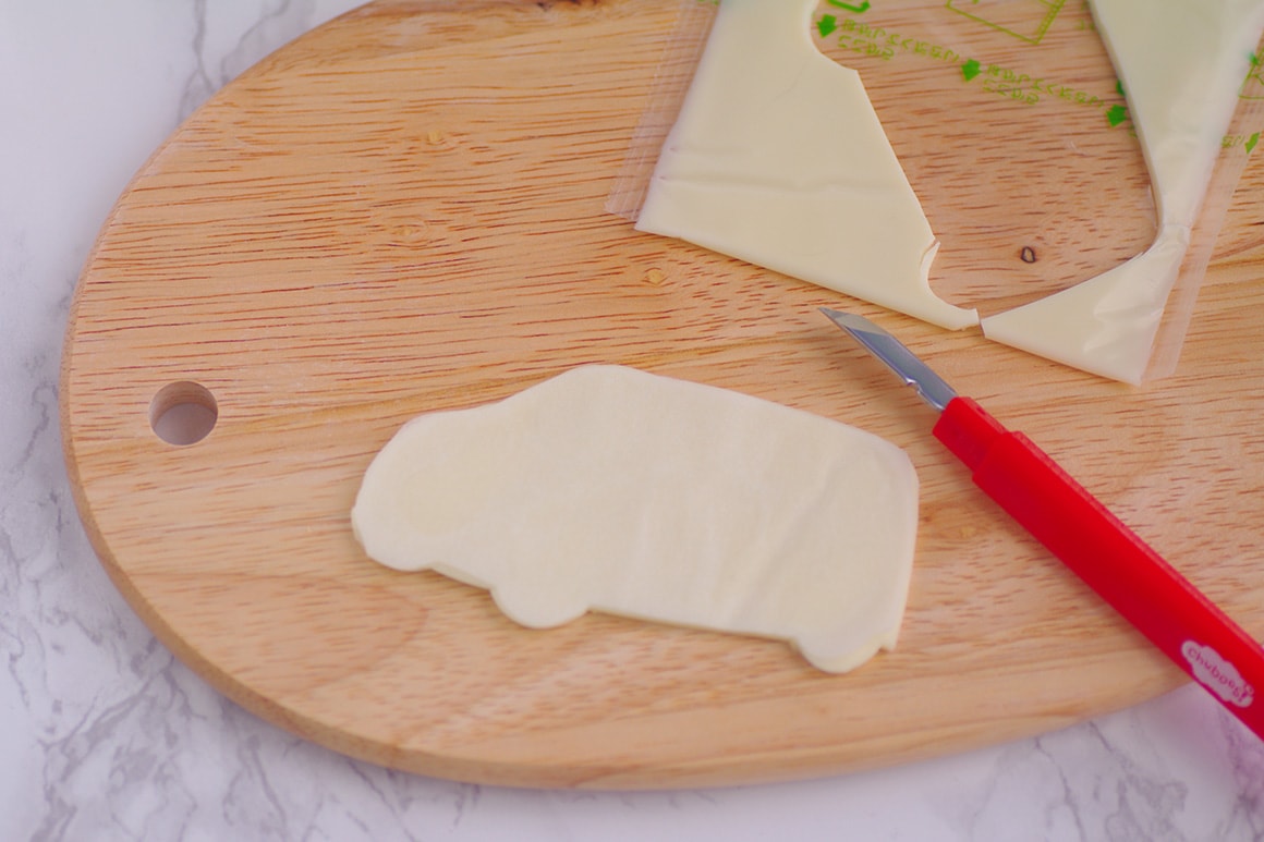 2. 型紙に沿ってお弁当用ナイフでスライスチーズをカットする(フロントグリルのカットの仕方に注意!)。