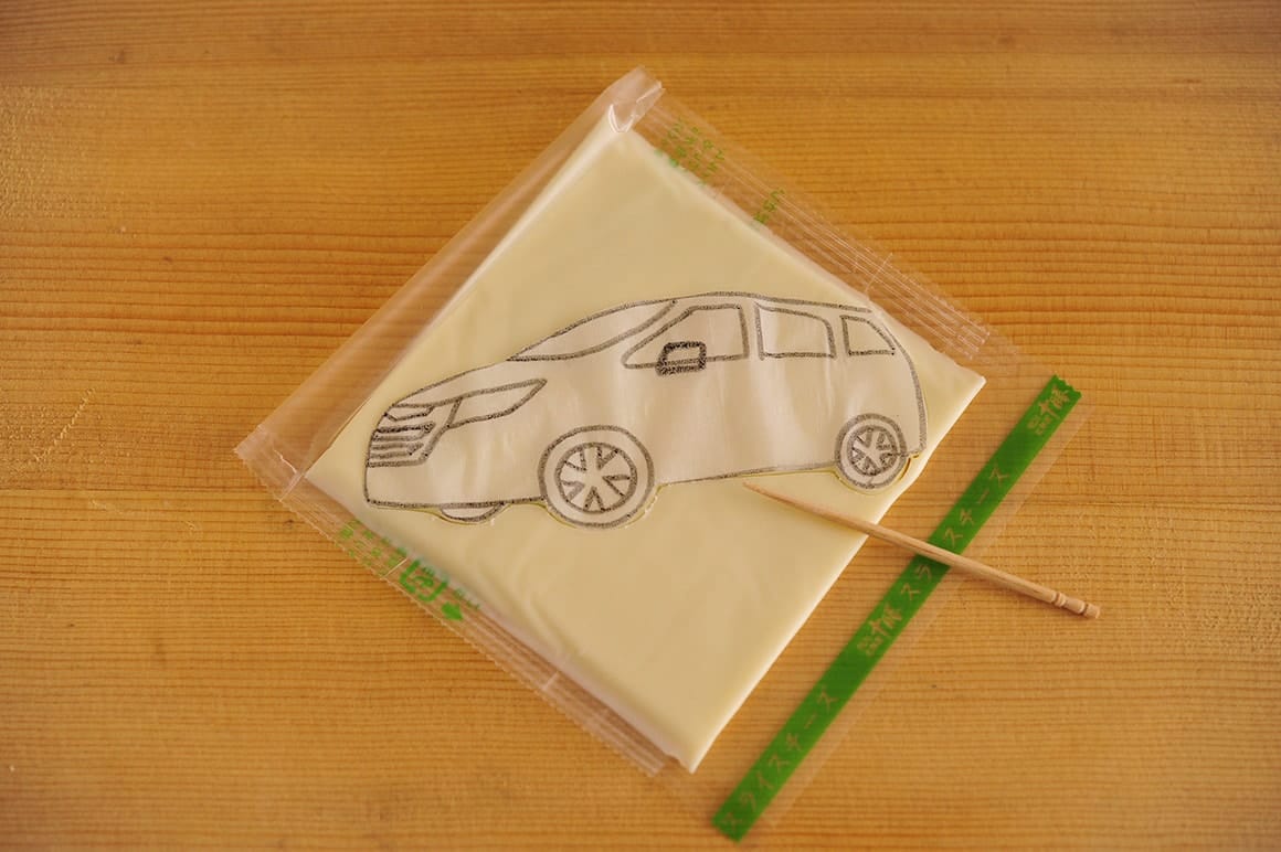 2. 1)の型紙をスライスチーズに乗せ、楊枝でカットし、土台を作る。