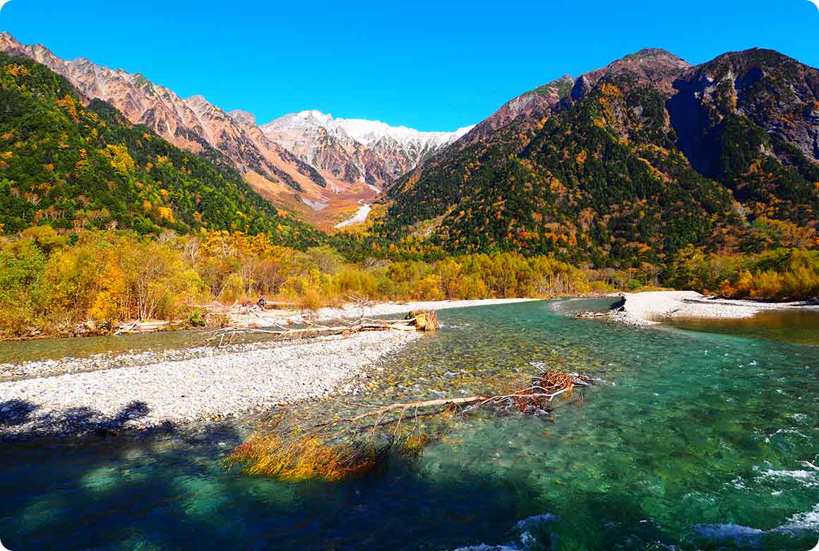 冠雪した穂高連峰と紅葉、そして澄み切った川のコントラストが美しい