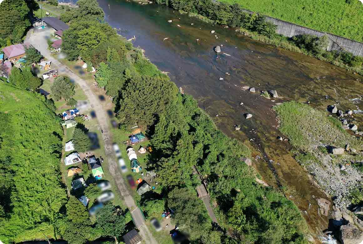 キャンプ場の全景。すぐそばに鬼怒川が流れ、山々に囲まれ自然豊かな環境